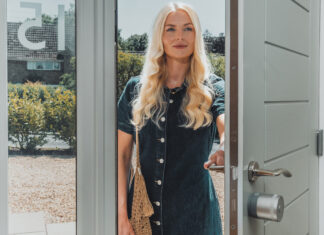 Yale Linus&reg; Smart Lock L2 Lite - Frau &ouml;ffnet eine T&uuml;r und geht ins Haus