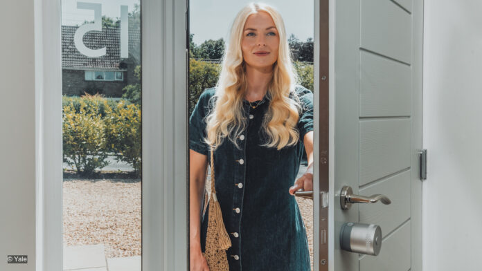 Yale Linus® Smart Lock L2 Lite - Frau öffnet eine Tür und geht ins Haus