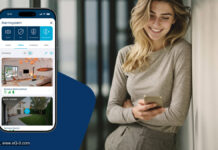 Homematic IP: App-Update 3.8.18 bringt neues Alarmsystem Frau hält Smartphone, Smartphone zeigt Homematic IP App