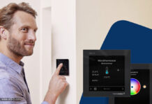 Homematic IP Glasdisplay – plus: Jetzt auch für Funk-Systeme und mit neuen Features Person steht vor einem Homematic-IP-Glasdisplay - plus