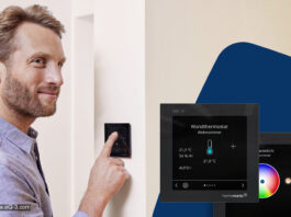 Homematic IP Glasdisplay – plus: Jetzt auch für Funk-Systeme und mit neuen Features Person steht vor einem Homematic-IP-Glasdisplay - plus