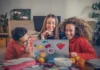 Sch&uuml;ler sitzen vor einem Laptop und lachen